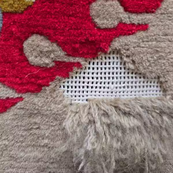 Close-up view of oriental rug surface pile repair showing detailed restoration work on worn and damaged areas