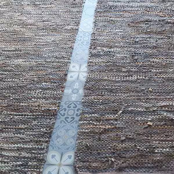 Technician performing controlled rug cutting and reshaping for interior fit in Auckland workshop