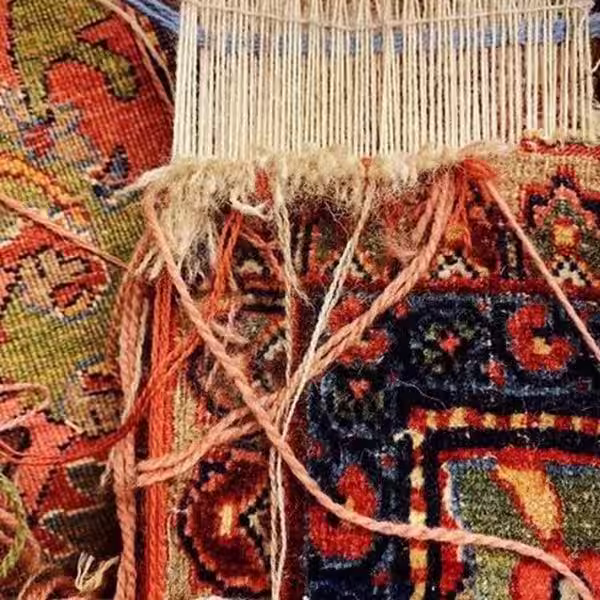 Halfway completed rug fringe repair showing restoration of missing or damaged fringe structure on handmade rug
