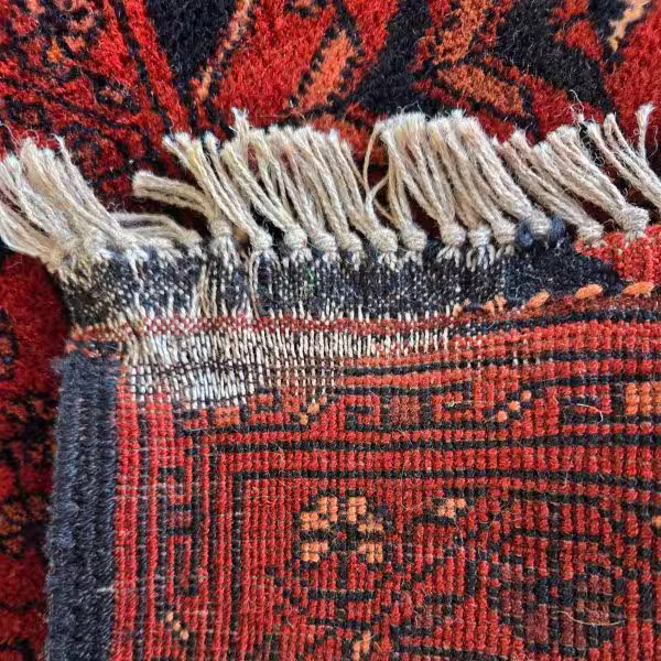 Rug moth damage in Auckland showing destruction of wool rug foundation and backing with missing fibres and structural weakening