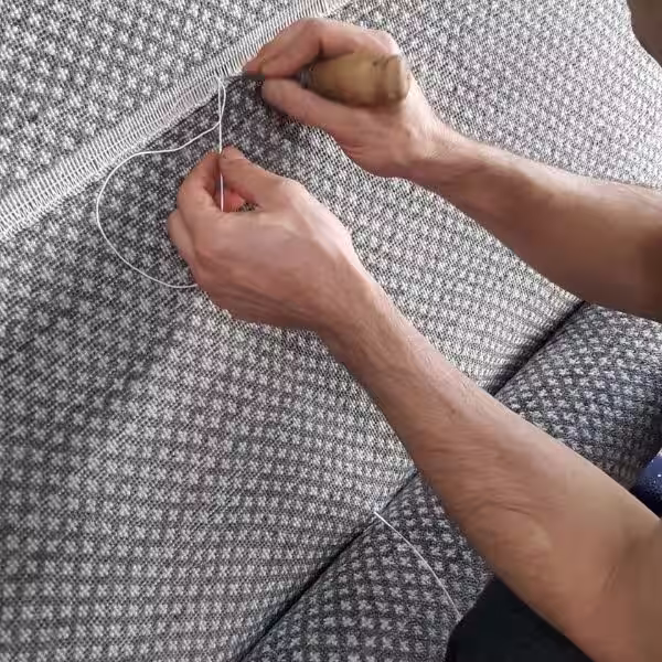 Severe rug damage repair showing large central hole being reconstructed through controlled reweaving and weft integration process