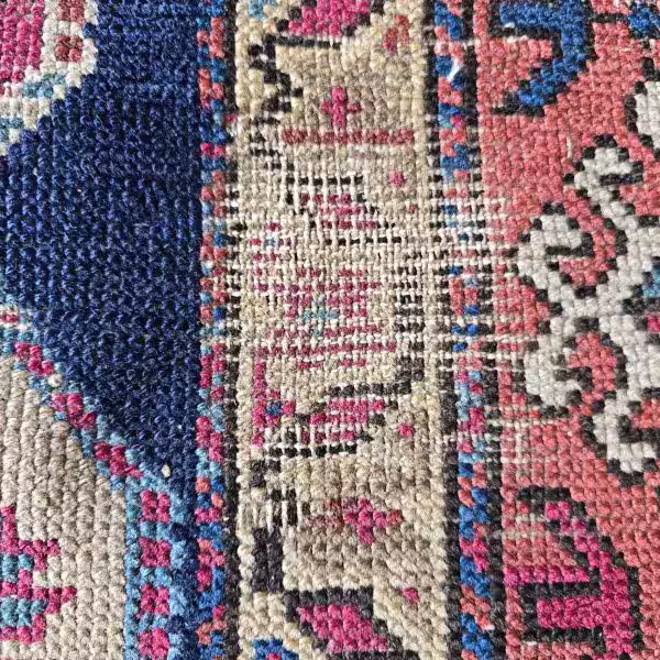Close up of artisan rug repiling restoring worn wool fibres in Auckland workshop