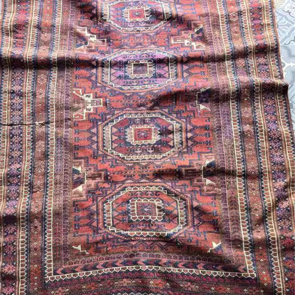 Handmade rug with visible ripples waves and buckling caused by structural tension imbalance