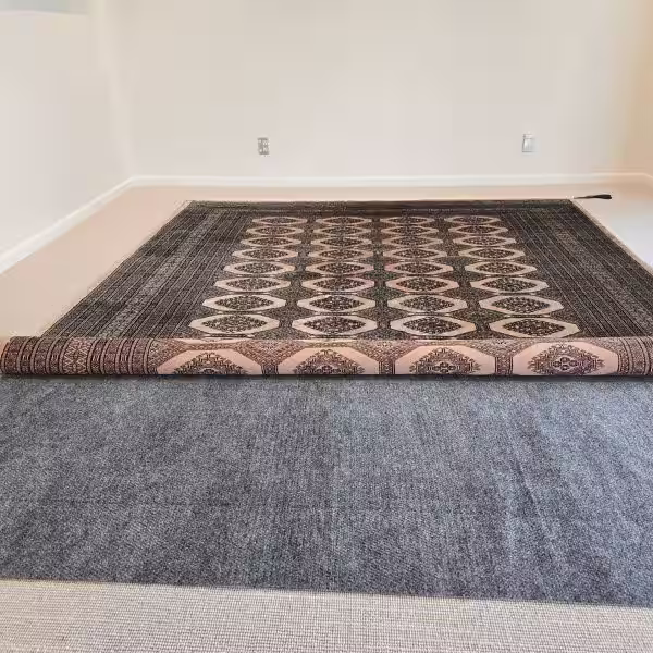 Anti-slip rug grip layer installed beneath a rug to reduce curling and movement