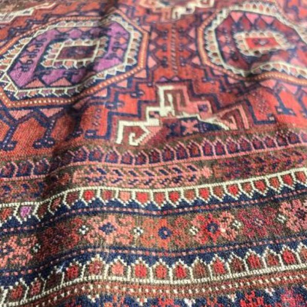 Bumpy rug surface with visible waves requiring professional rug stretching