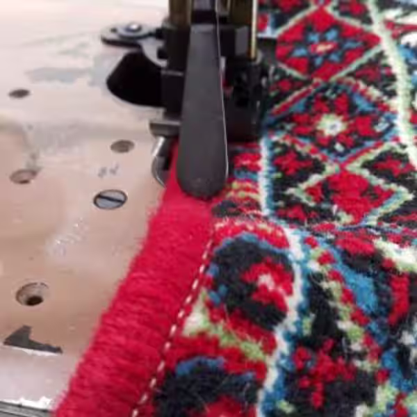 Close-up of machine overlocking stitching securing carpet edges to prevent unraveling and fibre loss