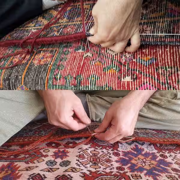 Hand rug binding specialist stitching edge reinforcement on handmade Persian rug in Auckland workshop