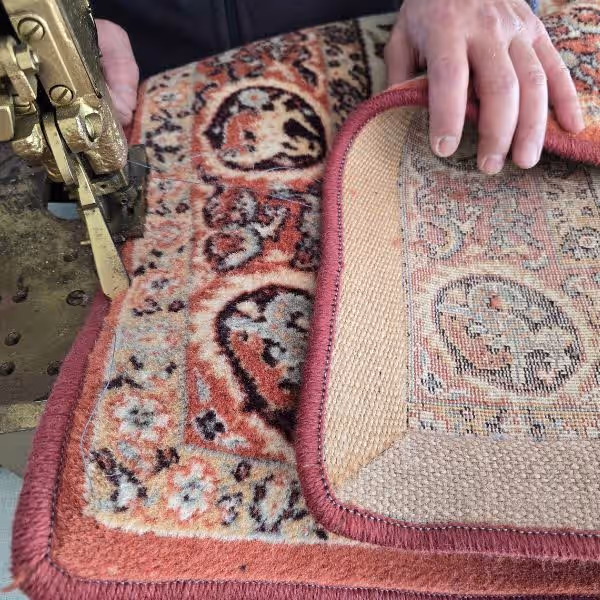 Professional workshop in Auckland performing carpet overlocking and edge finishing on custom carpets