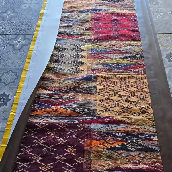 Moroccan runner before wide border edging completion during custom edging process at The Rug Guru