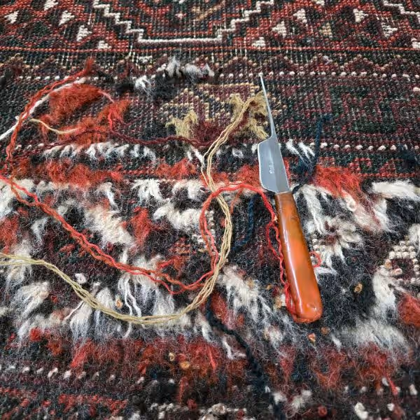 Rug surface repair showing pile rebuilding in high-wear zones